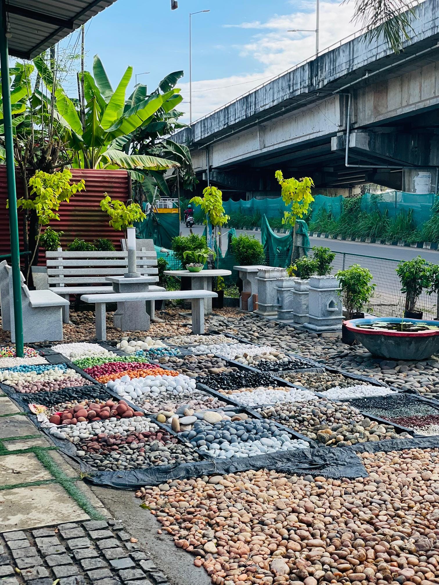 Interactive display layout showing organized pebble grids and hand-finished granite garden benches in Mannuthy, Thrissur
